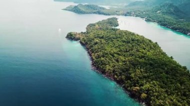 Turkuaz Okyanus Suyu ile çevrili yemyeşil ada yarımadasının hava görüntüsü