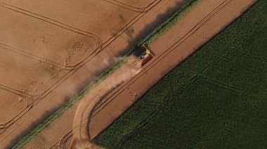 Ağır hasat makinelerinin ve traktörlerin yeni hasat edilmiş buğday tarlasında senkronize hareketlerini gösteren erik görüntüler modern tarımın gücünü ve ritmini gözler önüne seriyor.