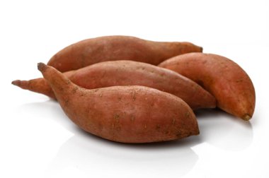 Pas rengi tatlı patatesler, eşsiz şekillerini ve topraksı cazibelerini sergileyerek yan yana yatar. Tarifler için mükemmeldir..