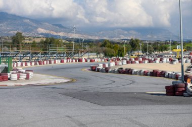 A vibrant kart racing track winds through stunning hills, inviting adrenaline-fueled competition under clear skies. clipart