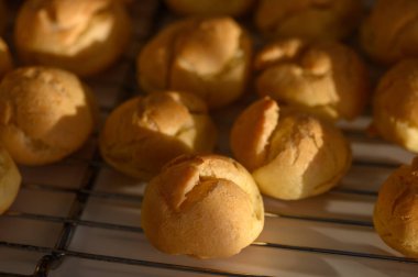 Ilık öğleden sonra ışığı taze pişmiş hamur işi puf puf soğur tel askıda, mutfağı zevkle doldurur..
