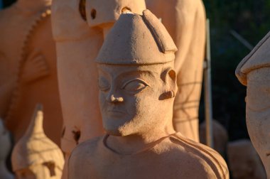 Karmaşık kil figürler açık havada canlı bir şekilde parlıyor, antik sanatın özünü somutlaştırıyor..