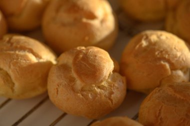 Taze pişmiş altın hamur işleri rafta serinliyor. Yumuşak dokuları, aroması sıcacık odayı doldururken lezzeti davet ediyor..