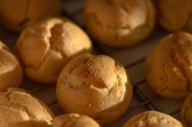 Altın-kahverengi hamur işleri serinletici bir rafta dinleniyor, sıcak ve davetkar aromalar saçıyor büyüleyici bir mutfak ortamında..