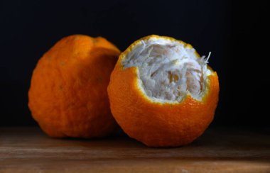 Ahşap bir yüzeyde parlak turuncu meyveler tatlı ve yumuşak iç organlarını göstererek, sıcacık bir mutfak atmosferine enerji katıyor..