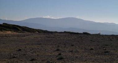Manzara, batmadan hemen önce doğanın dinginliğini yakalayan yuvarlak tepeler ve geniş bir alana sahiptir..