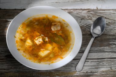 Kaliteli ahşap bir yüzeye kurulmuş canlı sebze ve tofuyla dolu lezzetli bir çorba kasesi..