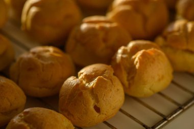 Sıcak, taze pişmiş altın hamur topları tel askıda oturur, büyüleyici bir mutfak ortamında serinler..