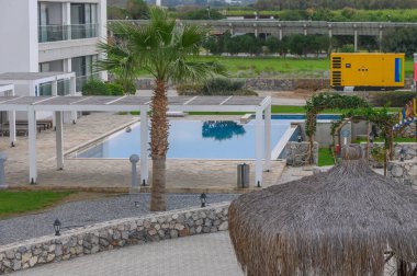 Parlak bir gökyüzünün altında sallanan palmiyeler ve barışçıl bir atmosferle çarpıcı bir havuz kenarı inzivasına çekiliyoruz..