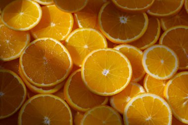 Renkli bir portakal dilimi dizilimi, sıcak güneş ışığı altında, doğal güzelliklerini gözler önüne seriyor..