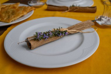 Ustaca hazırlanmış bir yemek rulo bir yaprağın üzerinde taze otlar, canlı sarı bir masa örtüsü üzerine kurulmuş..