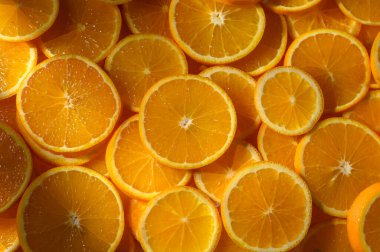 Taze kesilmiş portakal dilimleri sıcaklık ve renk yayar, güneşli bir mutfağa mutluluk ve sağlık hissi verir..