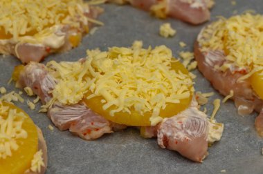 Tatlı ananas ve erimiş peynirle kaplı yumuşak tavuk parçaları lezzetli bir fırın için hazırlandı..