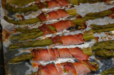 Pastırmaya sarılmış lezzetli kuşkonmaz ızgarada cızırdıyor, sıcak bir öğleden sonra yemeğinin tadını çıkarıyor..