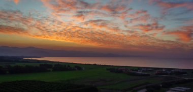 Güneş sakin kıyı şeridinde batarken, canlı renkler gökyüzünü dolduruyor, doğanın güzelliğine huzurlu bir kaçış sunuyor..