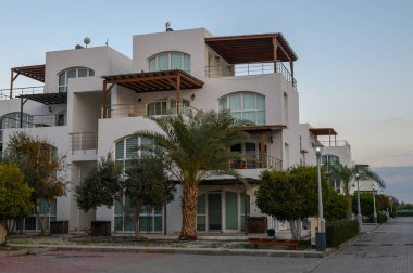 Palmiye ağaçlarının arasından yükselen lüks villalar alacakaranlık saatlerinde sahilin otantik atmosferini yakalıyorlar..