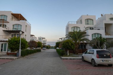 Huzurlu sokak vitrinleri. Çağdaş villalar. Yumuşak akşam ışıklarıyla yıkanmış..