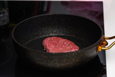 Taze bir biftek kesimi tavada usulca cızırdıyor, alacakaranlık yaklaşırken aşçılık hazırlığı sanatını sergiliyor..