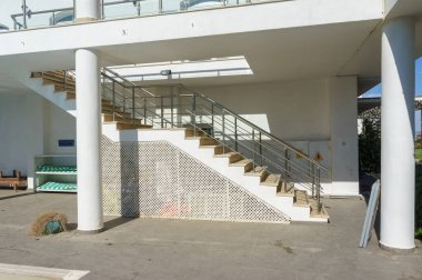 Parlak güneş ışığı parlak merdiveni aydınlatır ve dinlendirici havuz kenarında sıcak bir atmosfer yaratır..