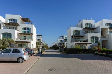 Büyük pencereli zarif binalar sakin bir sahil caddesi boyunca sakin bir atmosfer yaratır..