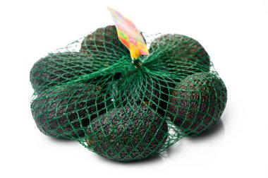 Bir ağa sarılı olgun yeşil avokado kümesi yumuşak dokusunu ve zengin rengini sergiliyor. Tarifler için mükemmel..