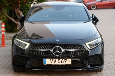 Gaziveren Kıbrıs Rum Kesimi -19.01.2025 Şık siyah bir araba modern bir ortamda belirgin bir şekilde duruyor, alacakaranlıkta lüks ve sofistike bir hava sergiliyor.