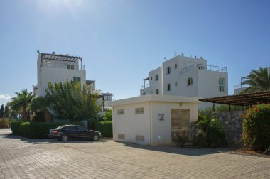 İki zarif beyaz yapı yemyeşil çimlerin ortasında duruyor. Parlak öğleden sonra güneşinin tadını çıkarıyorlar..