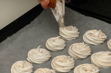 Pasta yapma sanatının keyfini çıkarırken sıcak bir mutfaktaki fırın örtüsünün üzerinde zarif kremalı pasta kıvrımları oluyor..