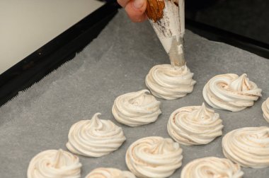 Narin krema kıvrımları ustalıkla parşömen kağıdına konuyor..