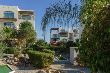 Bereketli yeşillik, güneşli bir günde ziyaretçileri villalara davet etmek için huzurlu bir yol açar..