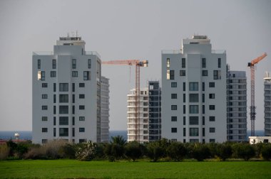 İkiz kuleler yemyeşil alanların üzerine yükselirken, inşaat çalışmaları yakınlarda devam ederken çağdaş mimariyi gözler önüne seriyor..