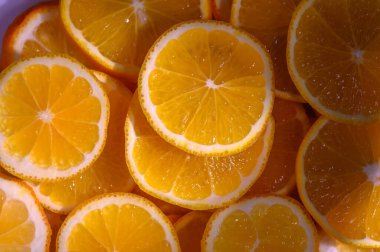 Taze kesilmiş portakal dilimleri sulu kısımlarını gözler önüne seriyor ve her türlü buluşmaya renk ve neşe katıyor..