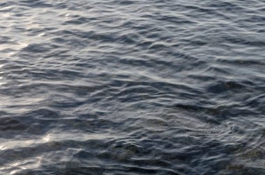 Yumuşak dalgalar, güneş batmaya başladığında büyüleyici desenler oluşturur. Durgun su yüzeyini güzelce aydınlatır..