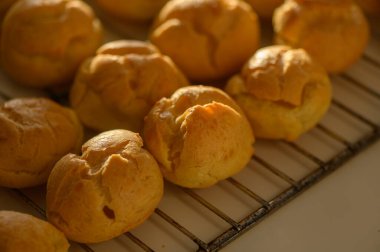 Taze kremalı puf börekleri sergiler havadar dokusunu ve altın rengini öğleden sonra ışığında.