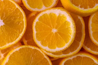 Canlı portakal dilimleri sulu iç kısımlarını sergiliyor, ılık havada ferahlatıcı bir renk ve tat patlaması yaratıyor..