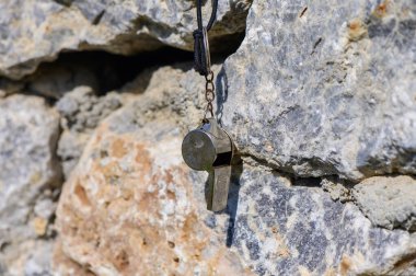 Parlak metal bir ıslık kayalardan sarkıyor, öğleden sonra ışığında parlıyor, macera hissi uyandırıyor.