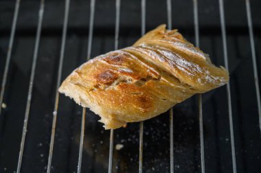 Nefis bir altın kruvasan tel askıda duruyor, buharın kaçmasına ve sıcak bir mutfakta serinlemesine olanak sağlıyor..