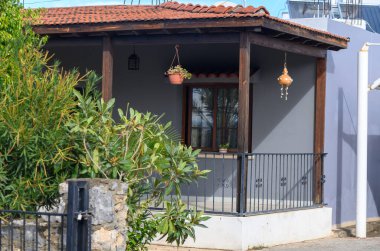 Bitkilerle ve hoş bir sundurmayla süslenmiş rahat bir ev, huzurlu bir açık hava ortamında rahatlamaya davetiye çıkarıyor..