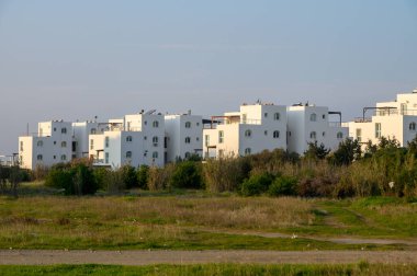 Parlak beyaz yapılar yemyeşil ortamda yükselir, huzurlu bir ortamda gün batımının sıcaklığını yakalar..