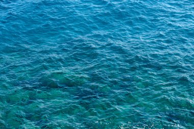 Canlı turkuaz sular güneş ışığını yansıtır ve parlak bir günde büyüleyici bir kıyı atmosferi yaratır..