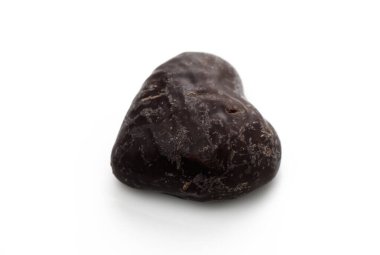 Hoş bir kalp şeklindeki çikolata temiz bir yüzeyde oturur ve tat alma duyusunu zengin lezzeti ve dokusunun tadını çıkarmaya davet eder..