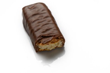 Çikolata kaplı lezzetli bir şekerleme davetkar bir şekilde dinleniyor, kremalı dolgusunu ortaya çıkarıyor, baştan çıkarıcı tatlı arzuları.