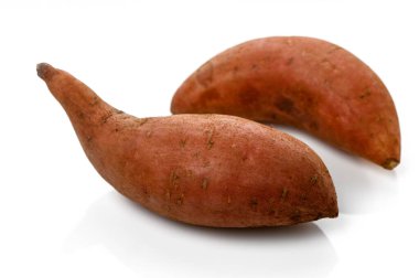 İki tatlı patates kırsal cazibelerini parlak beyaz bir arka planda sergiliyorlar. Mutfak yaratıcılığını ve lezzetini davet ediyorlar..