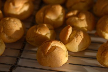 Ilık öğleden sonra ışığı taze pişmiş hamur işi puf puf soğur tel askıda, mutfağı zevkle doldurur..