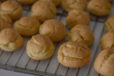 Yumuşak ve kabarık hamur işleri tel askıda dinleniyor, buharın kaçmasına izin vererek mutfağı sıcaklıkla dolduruyor..