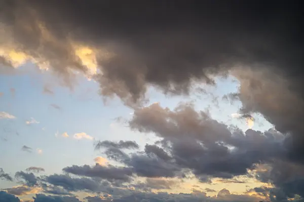 Dalgalanan bulutlar yaklaşan potansiyel bir fırtınayı işaret ederek gökyüzünü dolduran canlı renkler..