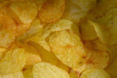 Kıtır kıtır patates dilimleri üst üste yığılmış, sizi arkadaşlarınızla hoş bir atıştırma deneyimine davet ediyor..