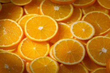 Parlak portakal dilimleri, sulu dokularını ve cazip aromalarını pazarda sergiliyorlar..