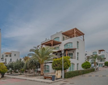 Modern konutlar zarif, palmiye ağaçları ve sakin bir öğleden sonra yürüyüş yollarıyla çevrili..