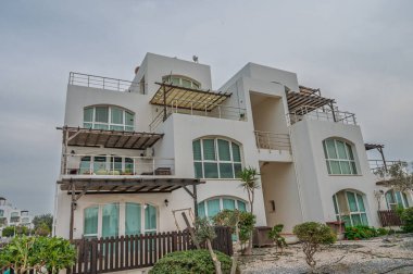 Sahil şeridine yakın, sakin manzaralı modern beyaz villa, rahatlamayı davet ediyor..